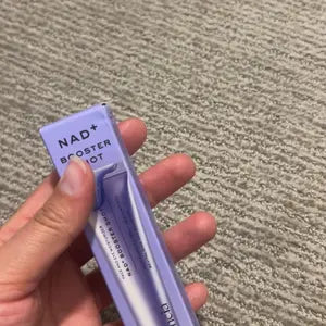 Customer holding the purple NAD+ Booster Shot box